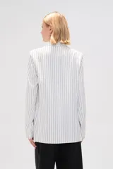 Blazer de viscosa a rayas verticales blancas y negras, con cuello solapa, cierre con botón y bolsillos delanteros.