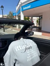 Remera rosa de corte recto con estampado en la espalda que incluye el texto "Itta Tours", "Tour", y nombres de ciudades como Ibiza, Madrid, Andorra, Barcelona y Formentera.