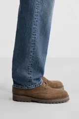 Bota de hombre color beige de cuero serraje con cordones, puntera redonda y suela track.