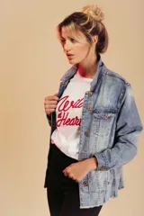 Remera blanca de algodón con cuello redondo y estampado frontal con la frase "Wild at Heart" en letras rojas.