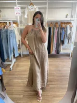 Vestido largo de lino color crudo, con escote halter fruncido y abertura lateral en la falda.