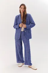 Blazer azul con textura, de corte clásico, con solapas de muesca, cierre frontal con botones y bolsillos con solapa.