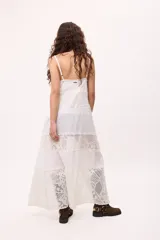 Vestido largo blanco con breteles finos, corte amplio y paneles de encaje.