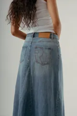 Falda larga de denim, tiro medio, color celeste claro con efecto desgastado. Presenta un corte amplio con paneles verticales que le dan volumen y caída.