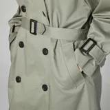 Gabardina verde militar con doble botonadura, cinturón con hebilla y cuello clásico.