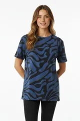 Remera de manga corta con estampado abstracto en tonos azules y negros, de corte holgado y cuello redondo.