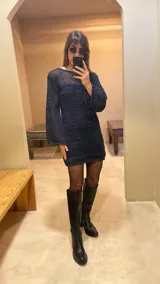 Minivestido tejido con lurex, color azul con brillos, de mangas largas acampanadas y corte holgado. Incluye un forro desmontable.