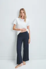 Pantalón acampanado azul marino de tejido de punto acanalado, con cintura alta y tres botones decorativos.