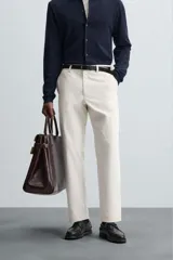 Pantalón chino de vestir negro, corte slim fit, con bolsillos laterales y traseros. Cierre frontal con cremallera y botón.