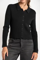 Cardigan negro de tejido de punto acanalado, con cuello polo, corte al cuerpo y cierre frontal con botones.