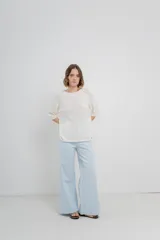 Pantalón de tiro alto, corte palazzo amplio y fluido, color celeste claro. Presenta bolsillos delanteros y traseros tipo jean, con logo metálico Peach en la parte posterior.