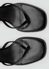 Sandalias negras de tacón bajo con punta cuadrada, cierre de tira con hebilla y diseño de tiras finas.