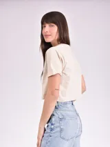 Remera corta blanca con estampa frontal de texto "Los Angeles" y una rosa en color rosa.