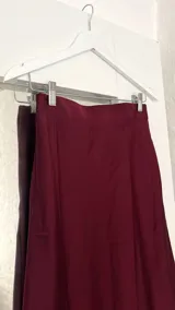 Pollera midi de seda color borgoña, con cintura elastizada.