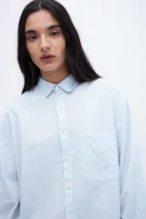 Camisa rosa claro de algodón con cuello solapa clásico, calce relaxed, bolsillo cuadrado en el pecho y botones personalizados.