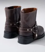 Bota corta negra de cuero vacuno con estribo desmontable, suela de caucho, cierre interno y punta redonda.