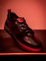 Zapatillas urbanas de cuero negro con detalles en rojo y logo de Star Wars en la lengüeta.