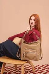 Cartera mochila color tostado, símil cuero, con compartimiento principal amplio y bolsillos frontales con cierre. Tiene correas ajustables para usar como mochila y asa superior para llevar al hombro.