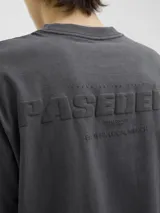 Camiseta gris oscuro de manga corta y cuello redondo con calce holgado y estampa pequeña en el pecho. Confeccionada en jersey simple peinado.