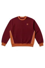 Buzo bordó de corte holgado con paneles laterales color ocre y vivo blanco. Tiene cuello redondo, puños y cintura acanalados. El logo de la marca está bordado en el frente.