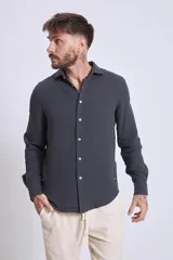 Camisa de manga larga color gris oscuro, con cuello clásico y cierre frontal con botones.