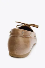 Zapato plano estilo náutico color marrón claro, con detalle fruncido en la parte delantera, suela a contraste y cierre mediante cordones.