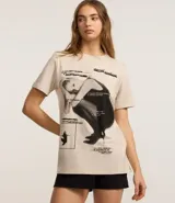Remera de algodón color crema con estampa frontal de Ariana Grande y texto en negro.