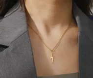 Collar dorado con dije de rayo.