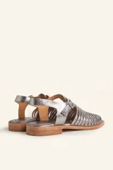 Sandalia de cuero color marrón con diseño de tiras entretejidas y hebilla lateral.