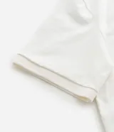 Remera boxy de mangas cortas confeccionada en algodón negro, con cuello polo y estampado frontal con el número 93, la palabra MAD en estilo gótico y una cruz. El algodón es certificado BCI.