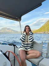 Buzo estilo marinero color crudo con franjas horizontales azul marino, confeccionado en 100% lana. Presenta cuello alto con cierre medio, puños y cintura ajustados.