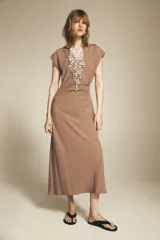 Vestido midi color beige con cuello solapa, escote en pico y manga corta. Cintura entallada con pliegues y cierre lateral con cremallera oculta.