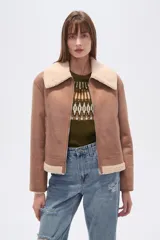 Campera estilo aviador color marrón claro, con cuello y forro de corderito color beige. Presenta cierre frontal y puños y ruedo con terminación de corderito.