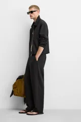 Pantalón negro de corte recto con cintura elástica, bolsillos laterales y un bolsillo trasero de ojal.
