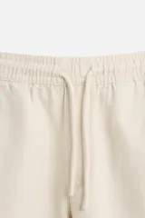Bermuda negra regular fit confeccionada en tejido de algodón con estructura. Cintura elástica ajustable con cordón, bolsillos laterales y bolsillo trasero de vivo.