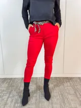 Pantalón rojo de corte Aline con cintura plisada y lazo con estampado animal print.