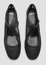 Zapato blanco con tacón bloque, tejido de malla semitransparente, cierre de hebilla y punta redonda.