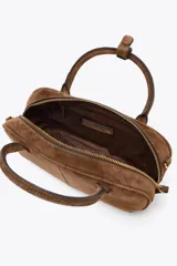 Bolso mini bowling color camel de serraje, con doble asa de mano y correa bandolera extraíble. Tiene un bolsillo interior con cremallera y cierre principal con cremallera y tirador.