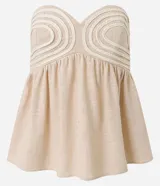 Blusa color beige sin breteles, confeccionada en viscolino con 15% de lino, con escote corazón, fruncidos y lastex en la espalda. La prenda tiene cuerditas aplicadas en el busto.