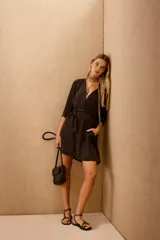 Vestido corto negro con escote en V, mangas 3/4 y lazo en la cintura.