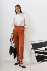 Pantalón de vestir color ladrillo, corte recto, con cintura elastizada y bolsillos laterales.