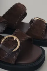 Sandalias de plataforma color verde militar, confeccionadas en cuero, con doble tira ancha con hebillas doradas y suela de goma negra.