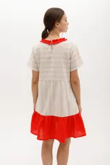 Vestido corto de algodón a rayas horizontales color beige, con cuello redondo negro y falda negra de lino.