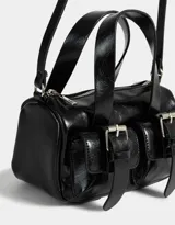 Cartera bowling negra de cuerina con manijas superiores, cierre superior y bolsillos frontales con hebillas. Incluye correa larga extraíble.