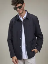 Campera azul marino de mangas largas con cuello camisero y cierre frontal con botones a presión.