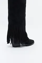 Bota texana de caña alta color beige confeccionada en gamuza, con punta fina, taco cuadrado de madera y detalle de flecos laterales. 