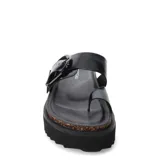 Sandalias planas color gris con hebilla metálica negra, tira ancha sobre el empeine y tira entre los dedos. Plataforma con base de corcho y suela de goma negra.