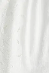 Top corto blanco de punto crepé con broderie, corte holgado, escote cuadrado y breteles finos ajustables.
