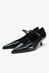 Zapato de cuero negro con tacón kitten, tira con hebilla ajustable y punta fina.