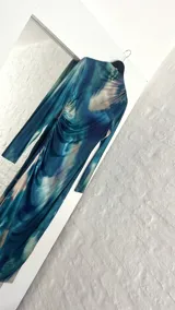 Vestido midi de cuello alto, color azul con estampado abstracto en tonos celeste, blanco y verde.